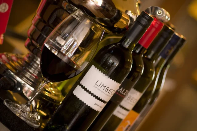 Rotwein und Weinflaschen auf einem Tisch.