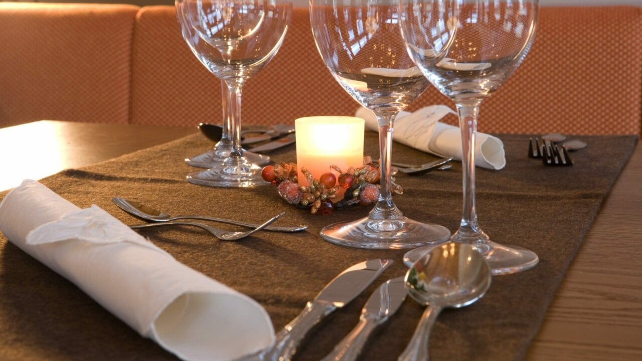 Elegant gedeckter Tisch mit Kerze und Gläsern.