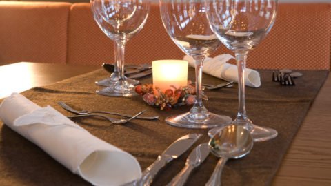 Elegant gedeckter Tisch mit Kerze und Gläsern.