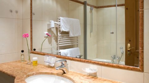 Helles Badezimmer mit Marmortisch und Spiegel