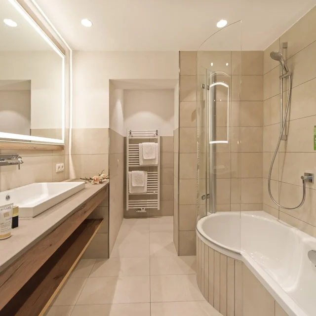 Helles modernes Badezimmer mit Badewanne und Dusche.