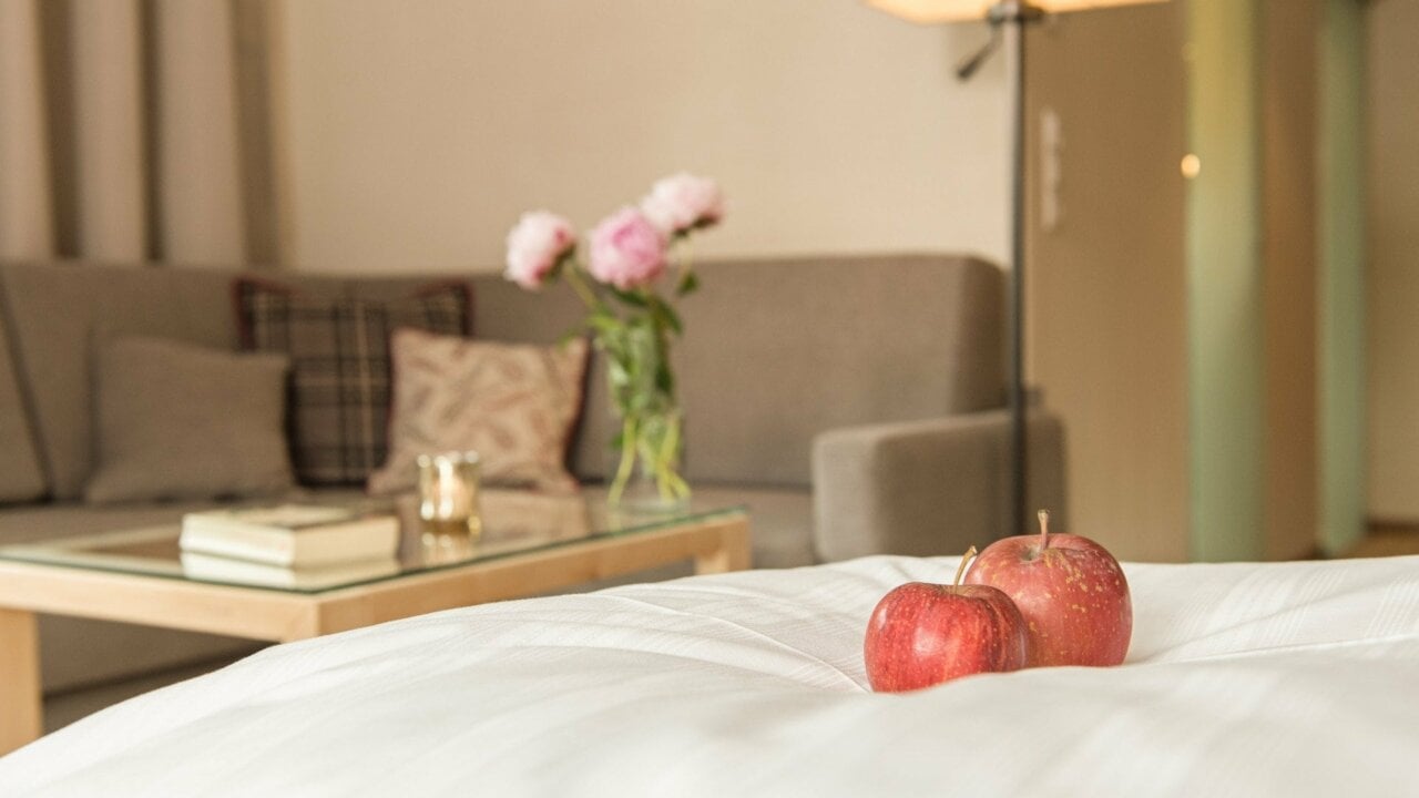 Gemütliches Wohnzimmer mit Äpfeln und Blumen.