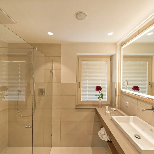 Modernes Badezimmer mit Dusche und Spiegel.