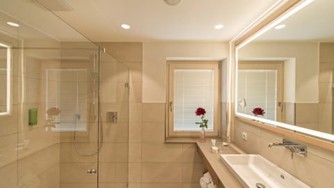 Modernes Badezimmer mit Dusche und Spiegel.