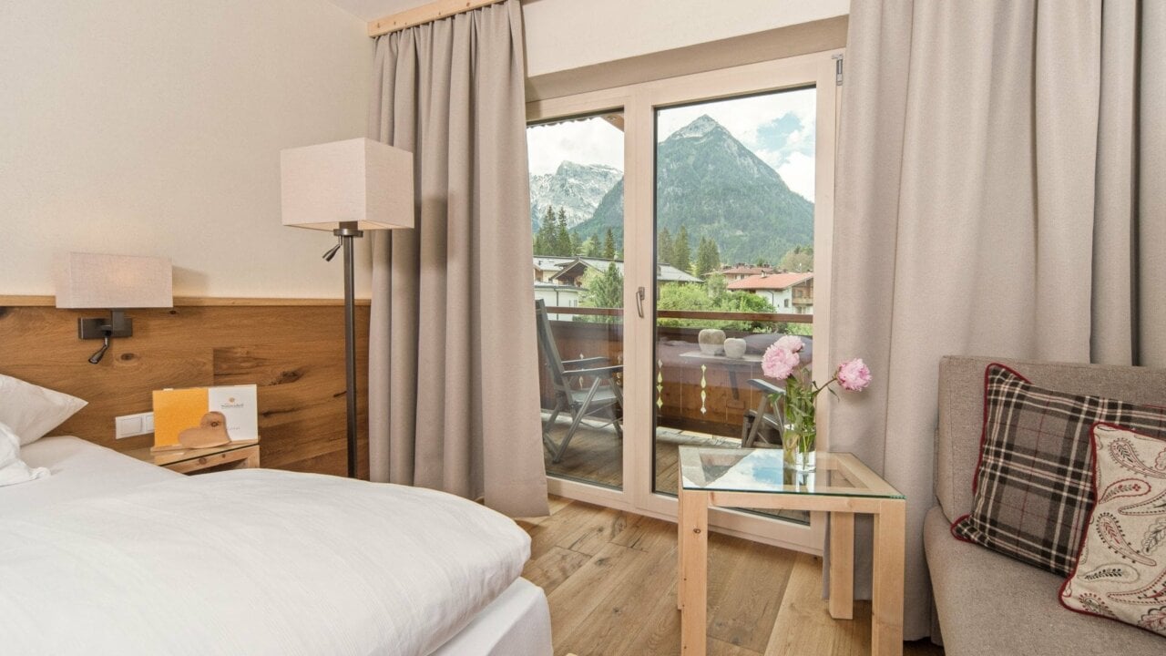 Helles Hotelzimmer mit Bergblick und Balkon