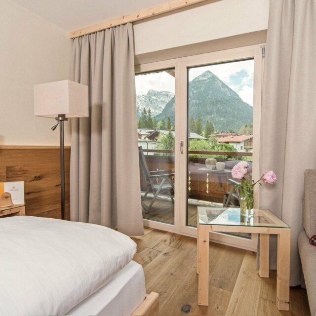 Helles Hotelzimmer mit Bergblick und Balkon