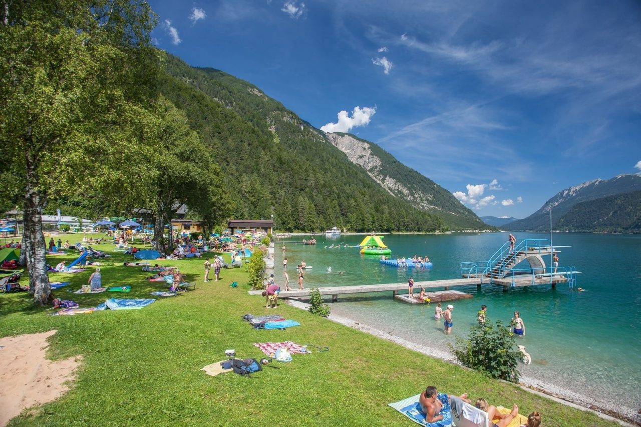 Badeplatz mit Menschen am klaren See