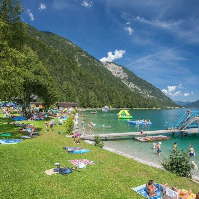 Badeplatz mit Menschen am klaren See