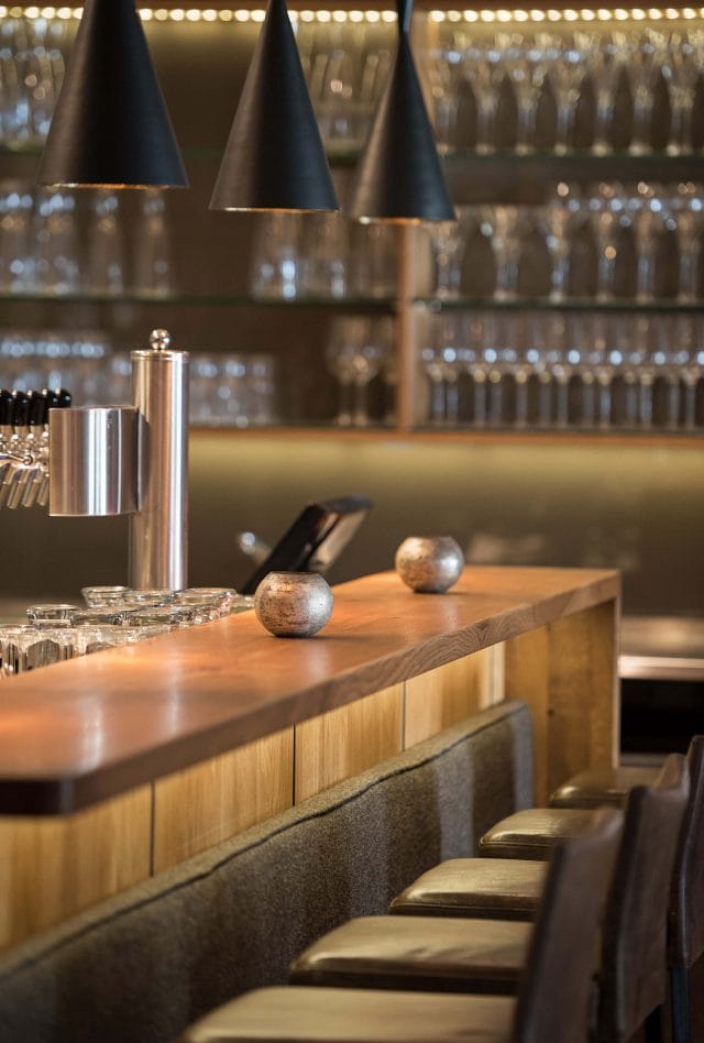 Moderne Bar mit Holztheke und Gläsern