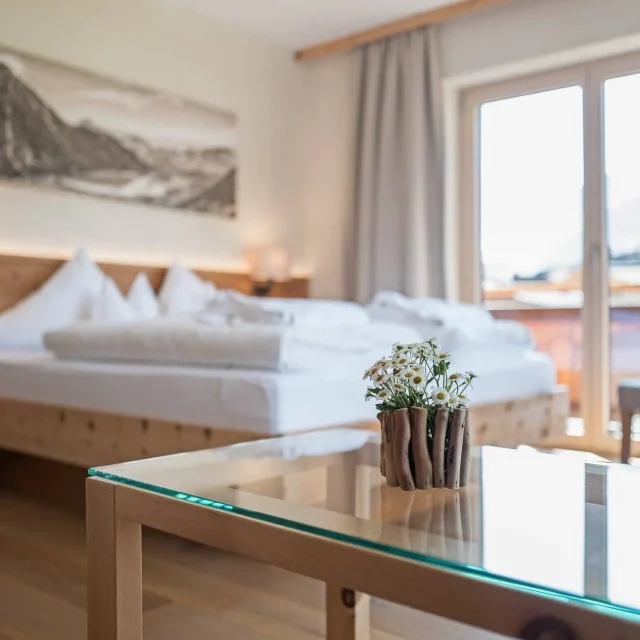 Helles Schlafzimmer mit Blumen und Holzdetails
