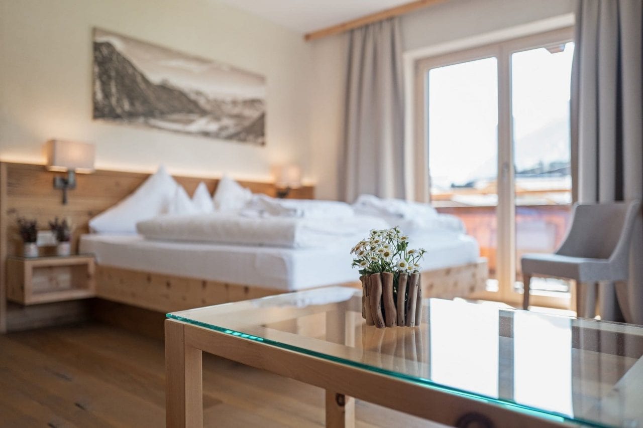 Helles Schlafzimmer mit Blumen und Holzdetails
