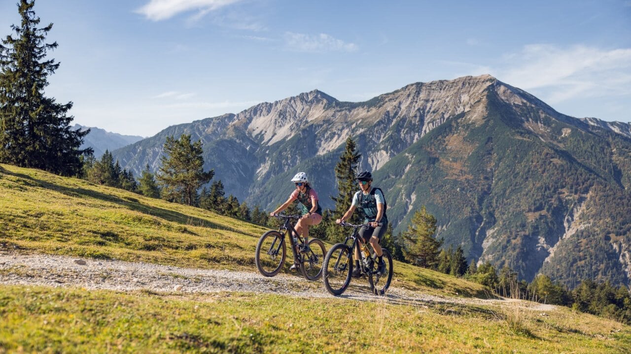 Radfahrer genießen Natur und Berge bei Sonnenschein.
