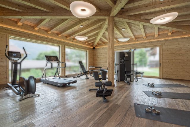 Fitnessraum mit Geräten und Holzinterieur