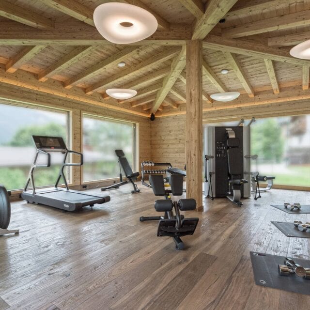 Fitnessraum mit Geräten und Holzinterieur