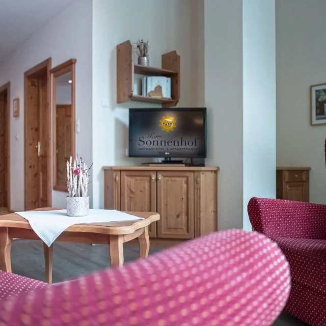 Gemütliches Wohnzimmer mit Fernseher und Möbeln.
