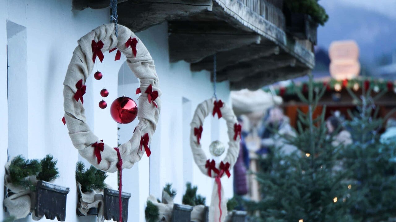 Weihnachtliche Dekoration mit Kränzen und Kugeln.