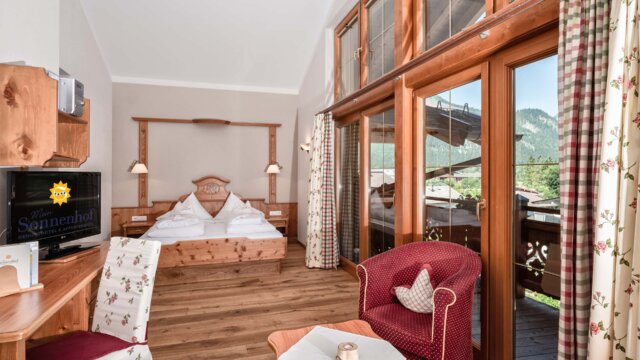 Gemütliches Hotelzimmer mit Balkon und TV.