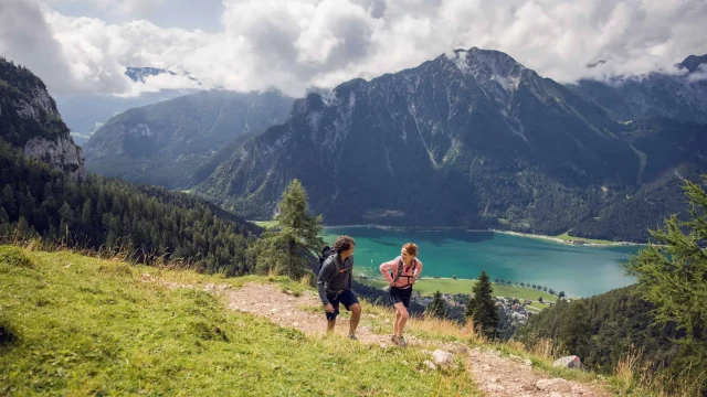 Wanderer in den Bergen mit See im Hintergrund