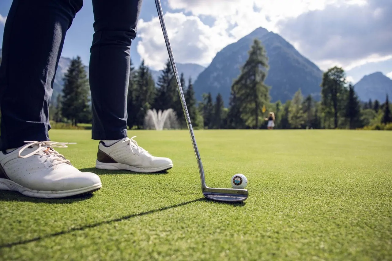 Golfspieler mit Putter auf dem Grün
