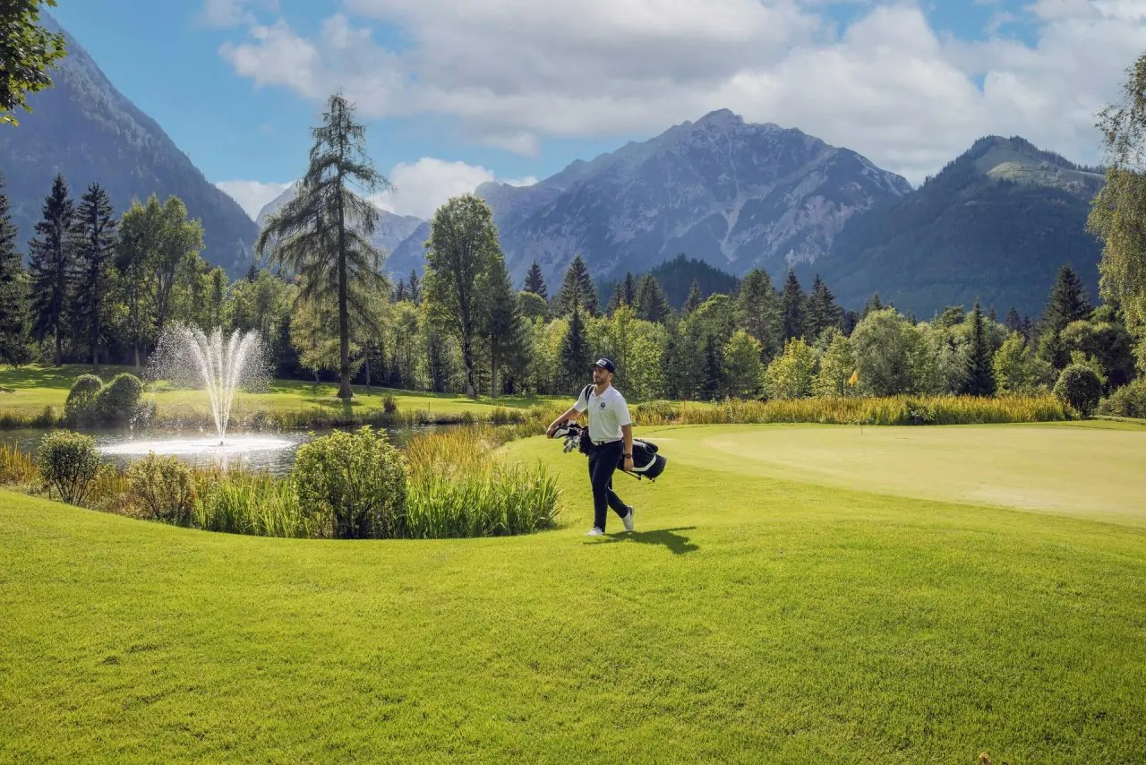 Golfspieler auf einem Platz mit Bergen im Hintergrund