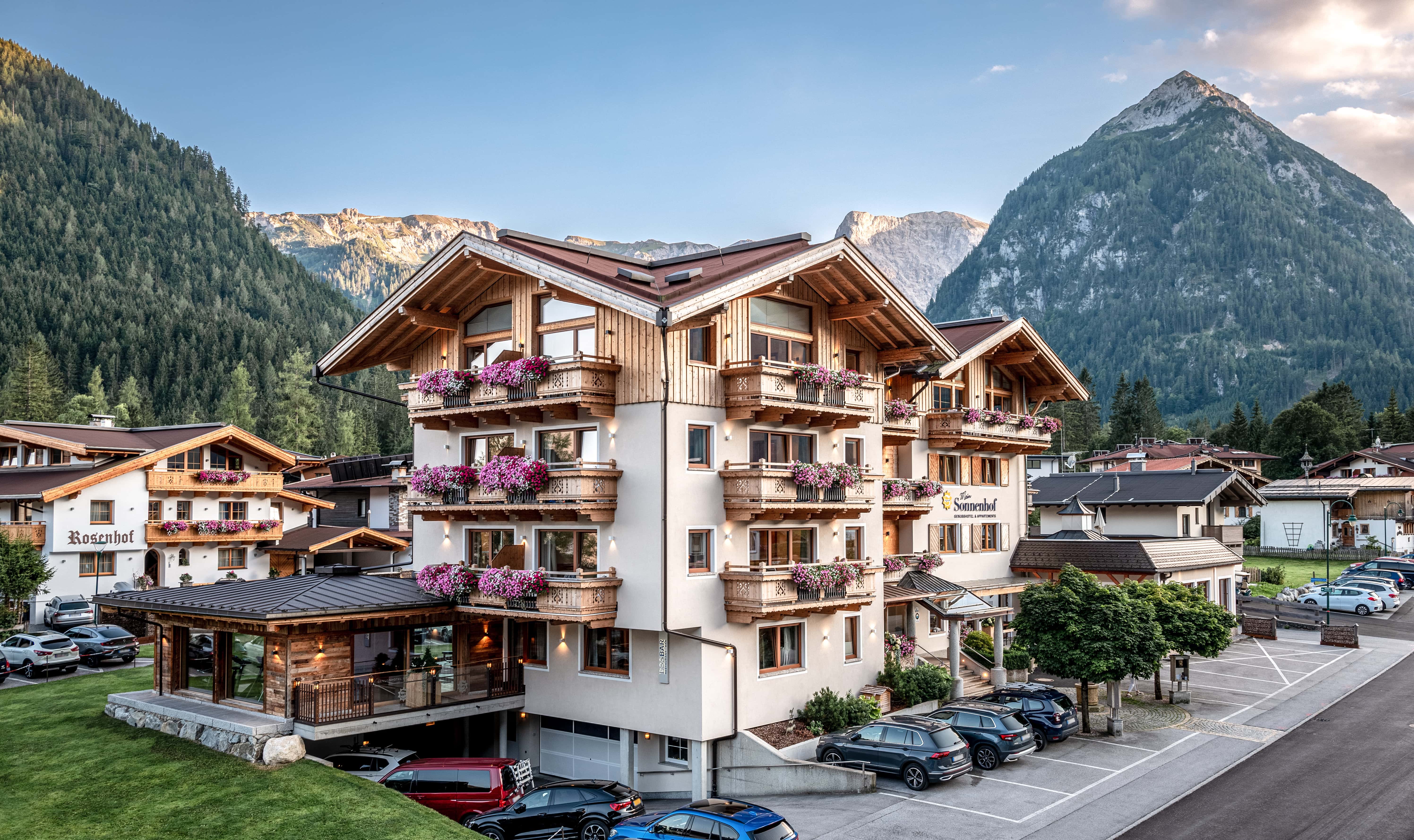 Alpenhotel mit Blumenkästen und Bergblick