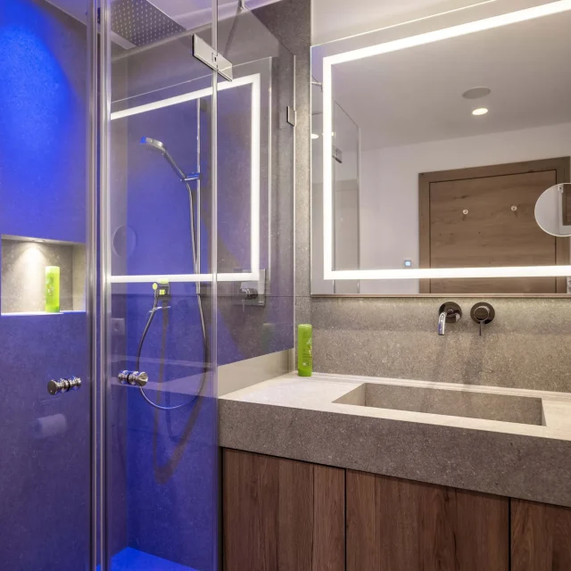 Modernes Badezimmer mit Dusche und Spiegelbeleuchtung