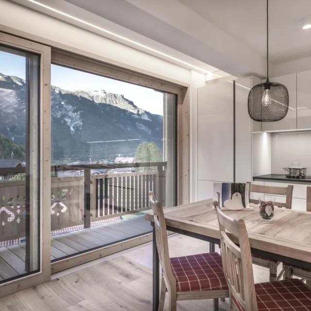 Moderne Küche mit Bergblick und Esstisch.