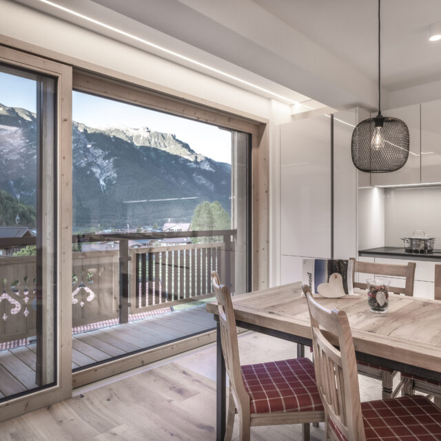 Moderne Küche mit Bergblick und Esstisch.
