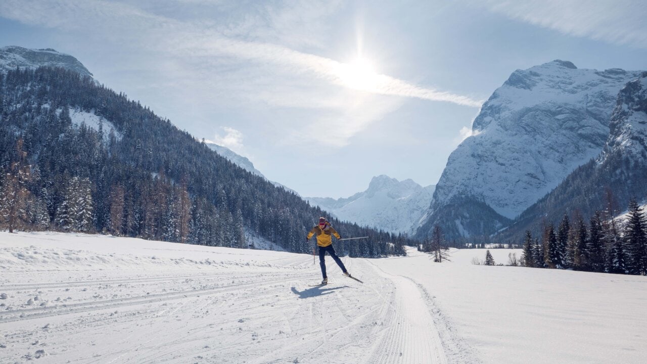 Langlaufender Sportler in winterlicher Berglandschaft