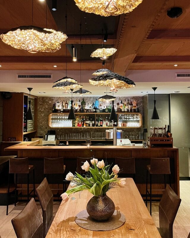 Moderne Bar mit stilvollen Lampen und Blumen