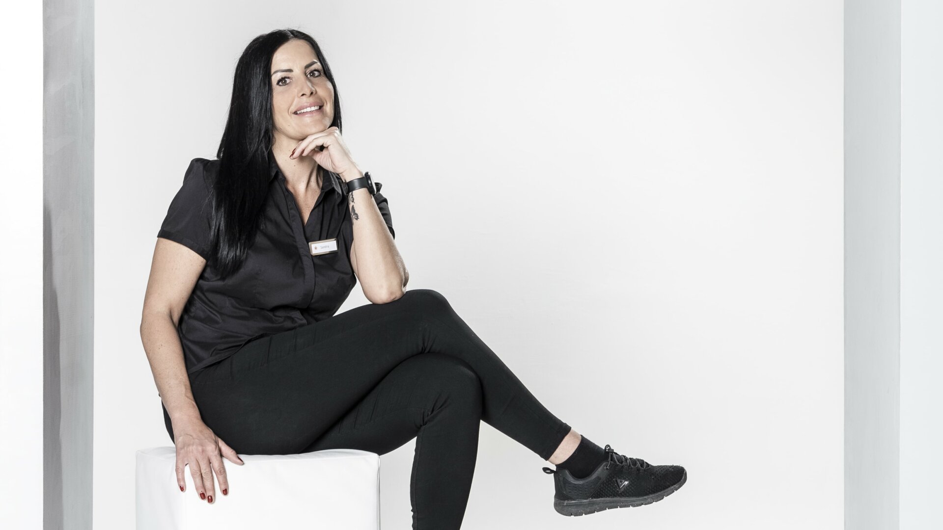 Frau sitzt entspannt in einem modernen Rahmen.