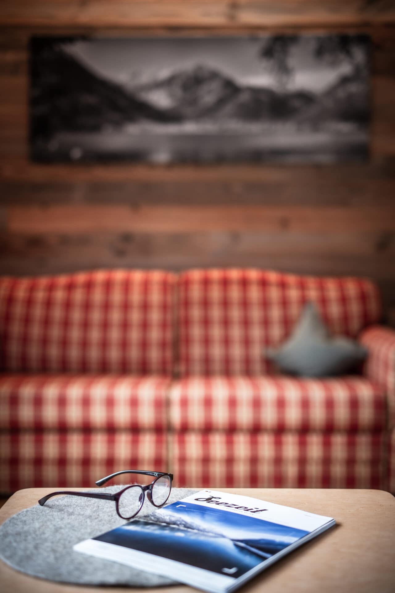Brille und Magazin auf Tisch vor Couch