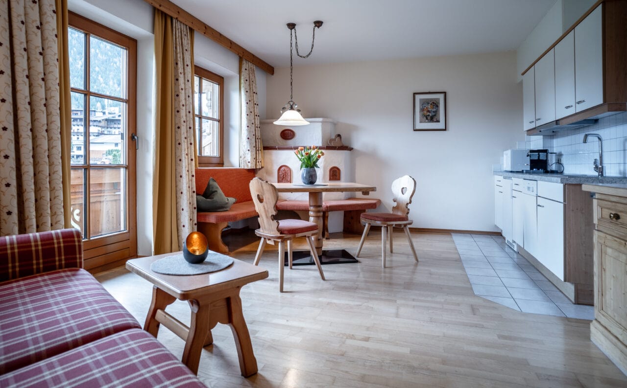 Helles Wohnzimmer mit Holzmöbeln und Küche