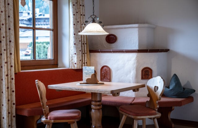 Gemütliche Essecke mit Kamin in Holzoptik.