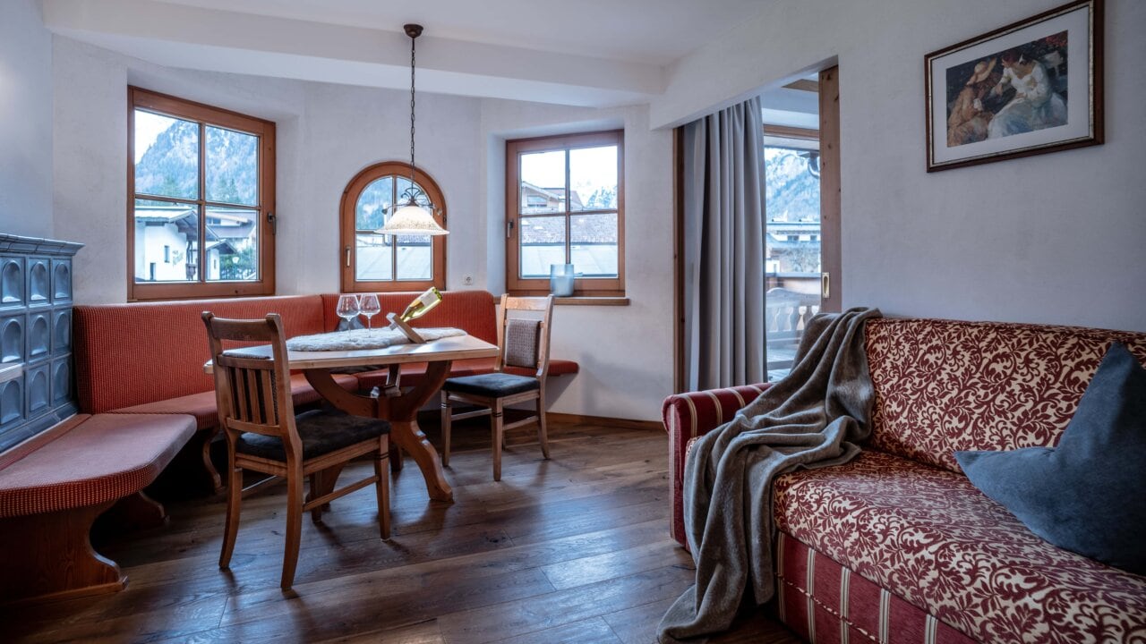 Gemütliche Wohnzimmer-Ecke mit Holz-Esstisch und Sofa.