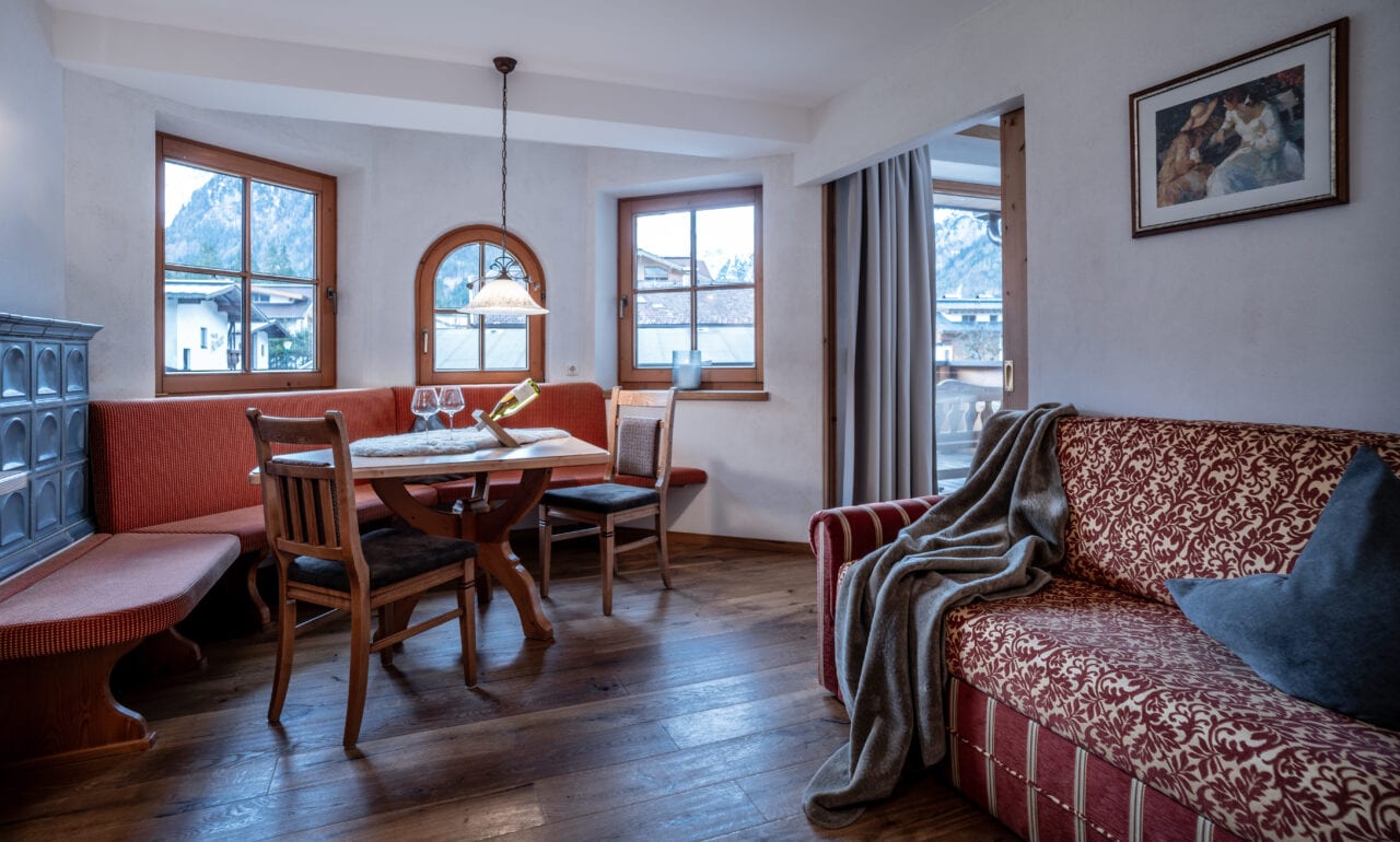 Gemütliche Wohnzimmer-Ecke mit Holz-Esstisch und Sofa.