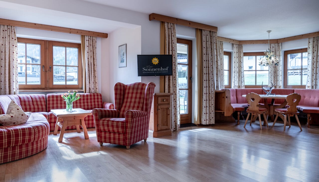 Gemütliches Wohnzimmer mit karierten Möbeln und Tisch.