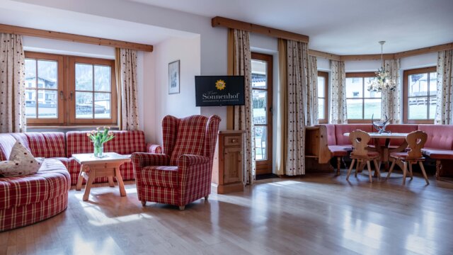 Gemütliches Wohnzimmer mit karierten Möbeln und Tisch.