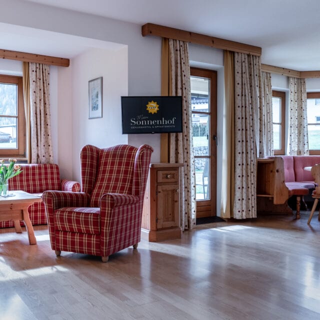 Gemütliches Wohnzimmer mit karierten Möbeln und Tisch.