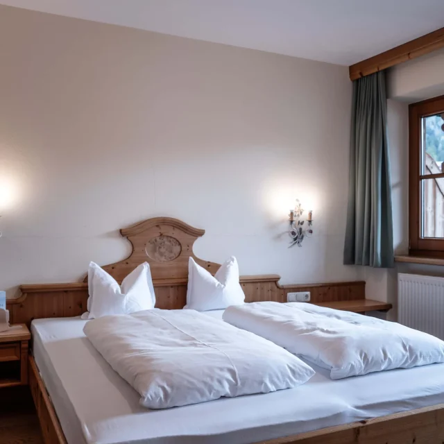 Gemütliches Zimmer mit Doppelbett und großem Fenster.