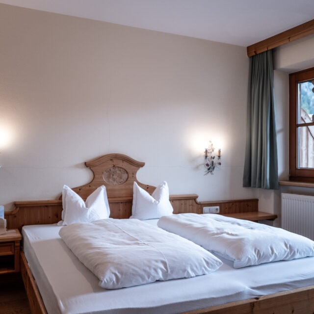 Gemütliches Zimmer mit Doppelbett und großem Fenster.