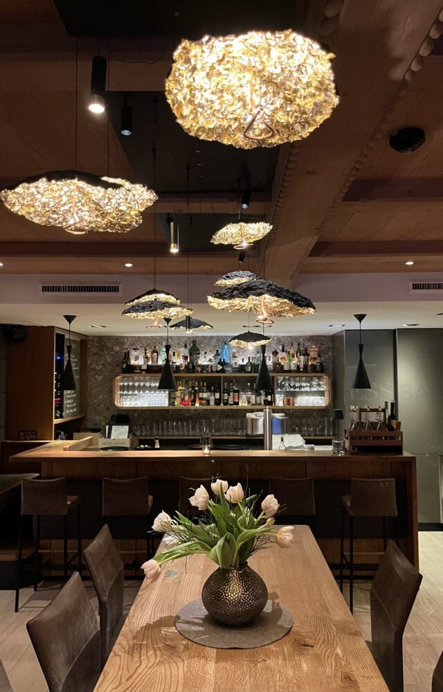 Moderne Restaurantbeleuchtung mit Blumenarrangement