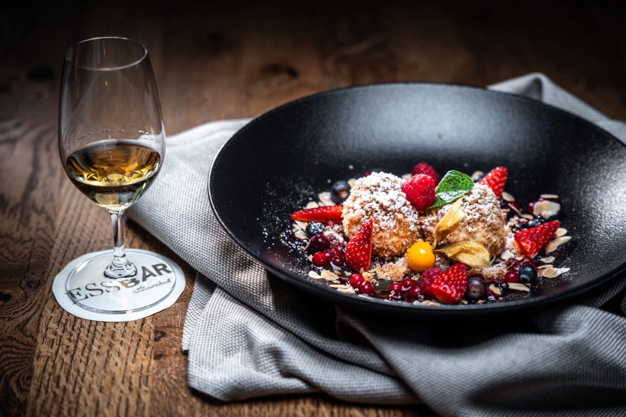 Dessert mit Früchten und Glas Wein.