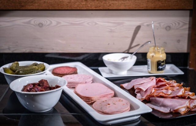 Vielfalt an Wurst und Beilagen auf einem Tisch.