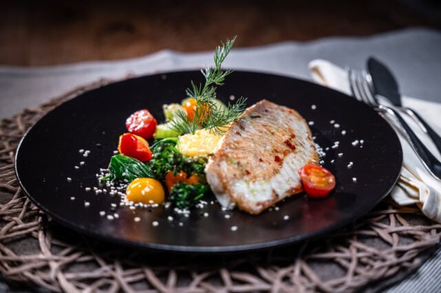 Gegrillter Fisch mit buntem Gemüse auf einem Teller