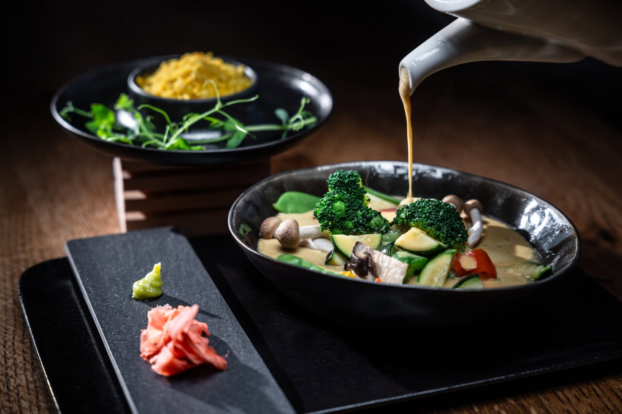 Asiatischer Gemüseeintopf mit Brühe und Beilagen.