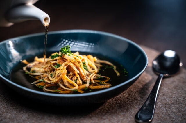 Schüssel mit Nudeln in klarer Brühe