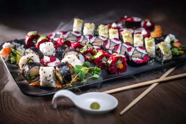Bunte Sushi-Platte mit verschiedenen Rollen und Wasabi.
