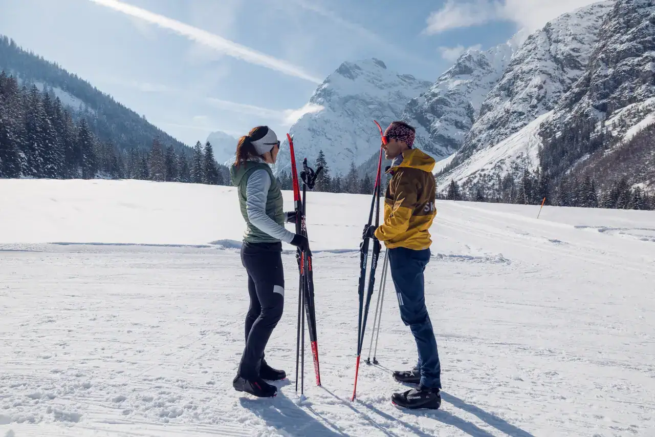 Skifahrer im Schnee vor gebirgiger Kulisse.