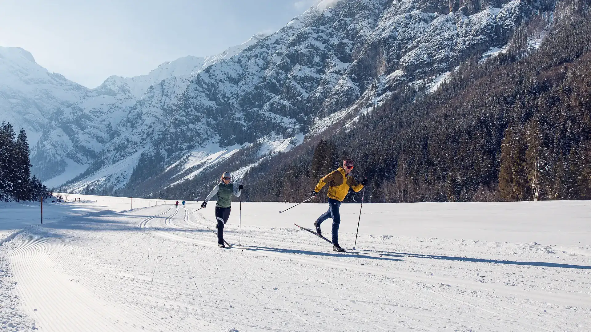 Skifahrer im Schnee vor majestätischen Bergen